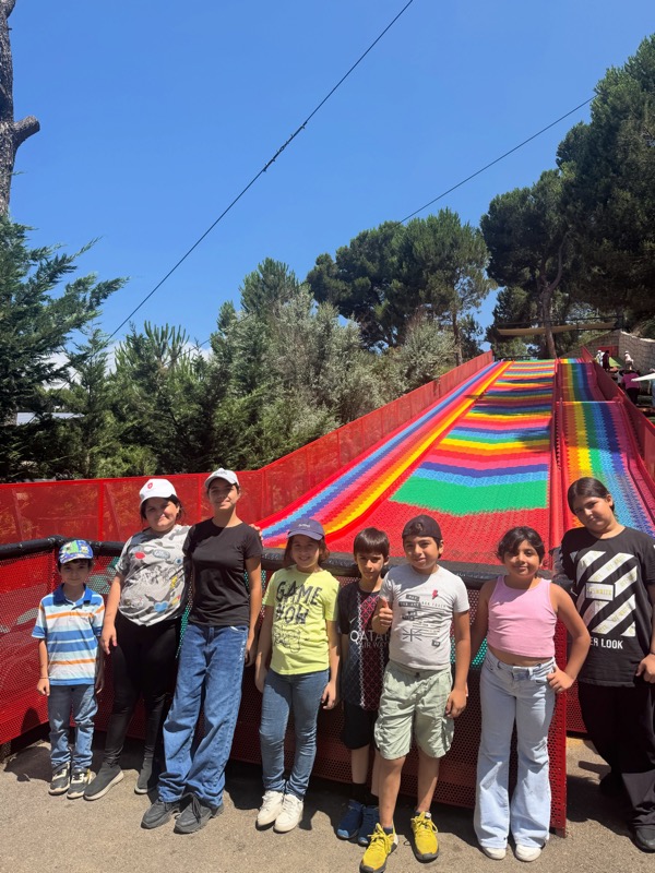 Children lined up in front of a rainbow slide