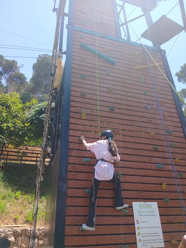 A child climbing a wooden climbing wall
