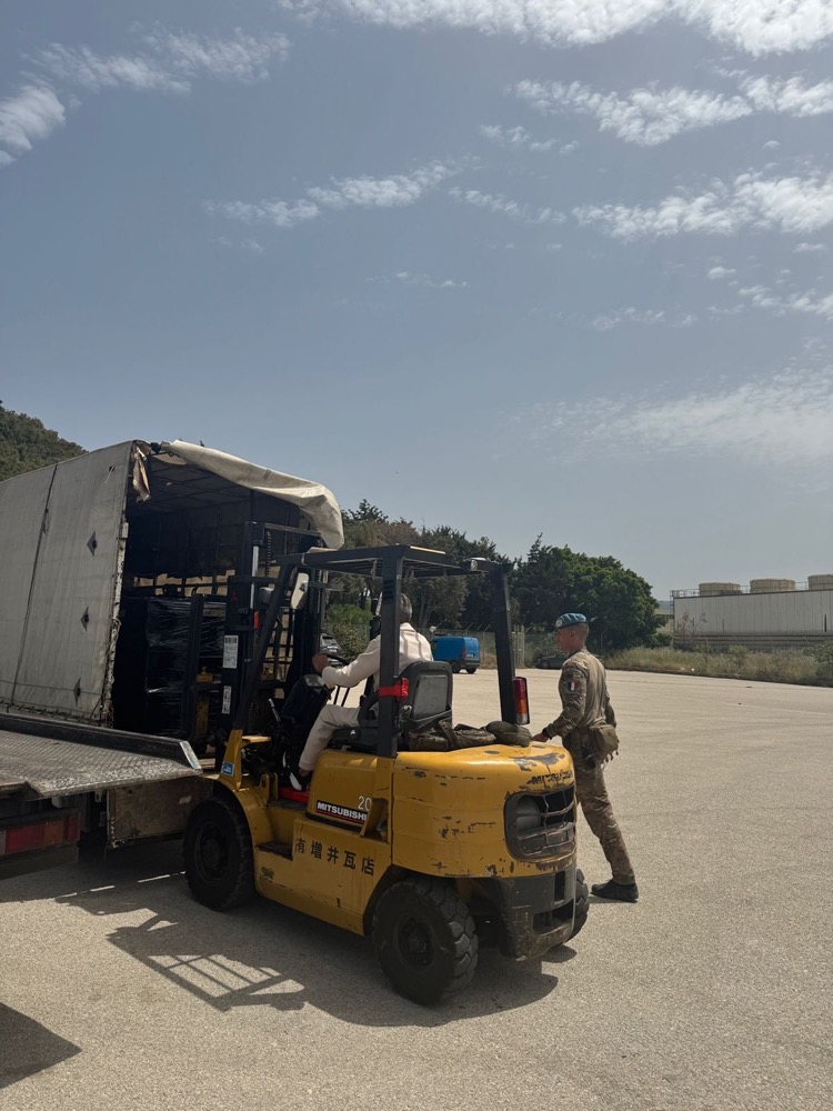 A forklift unloading a pallet of donated food from a truck