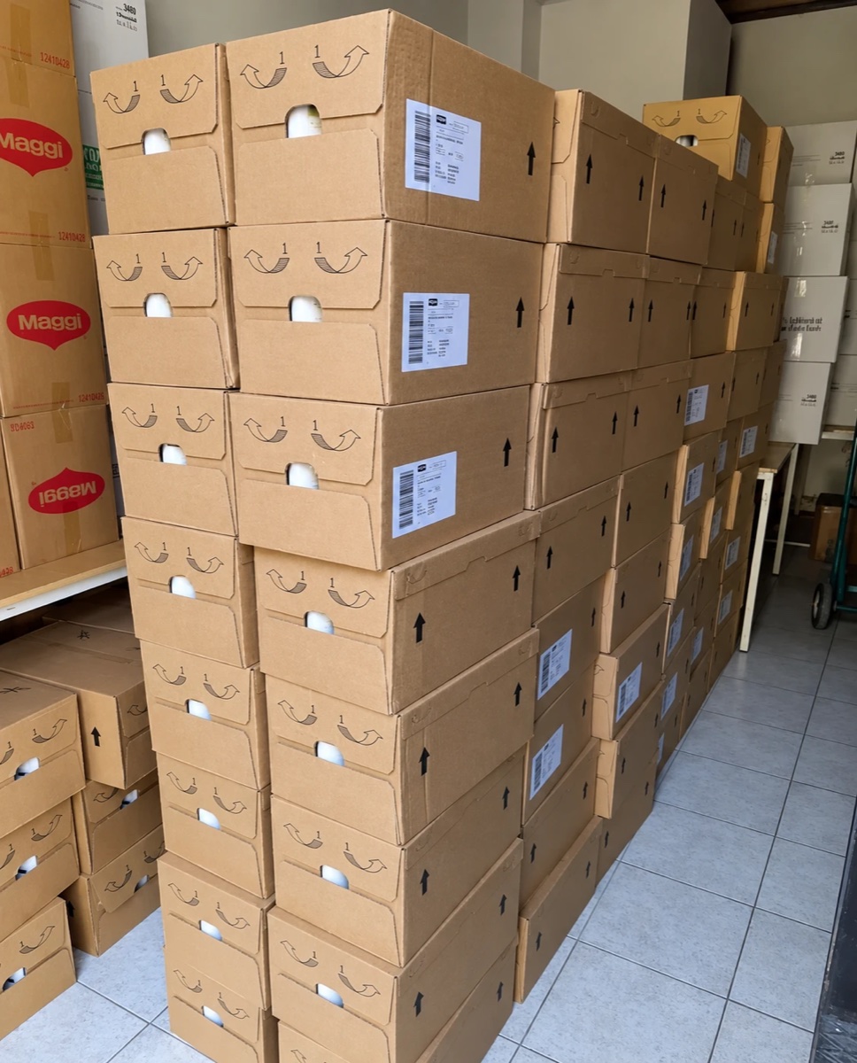 Tall stacks of cardboard boxes of food supplies in a storeroom