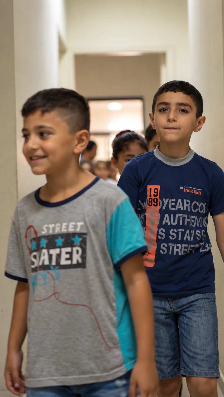 Two boys walking down a corridor